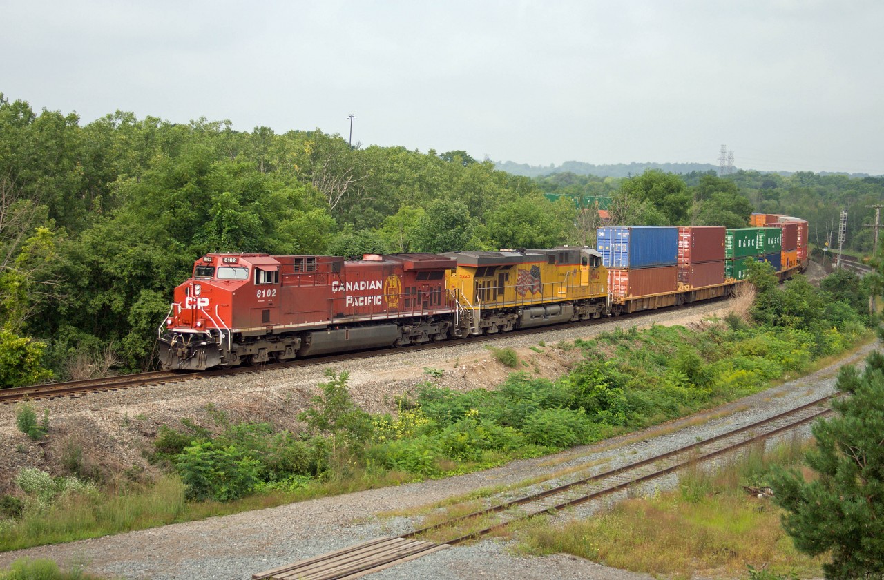 CP 143 approaches Desjardins behind two AC traction units--CP 8102 (rebuilt from 9645)and UP 5442...before 143 finishes descending the hill, CN 148 will pass in the background!