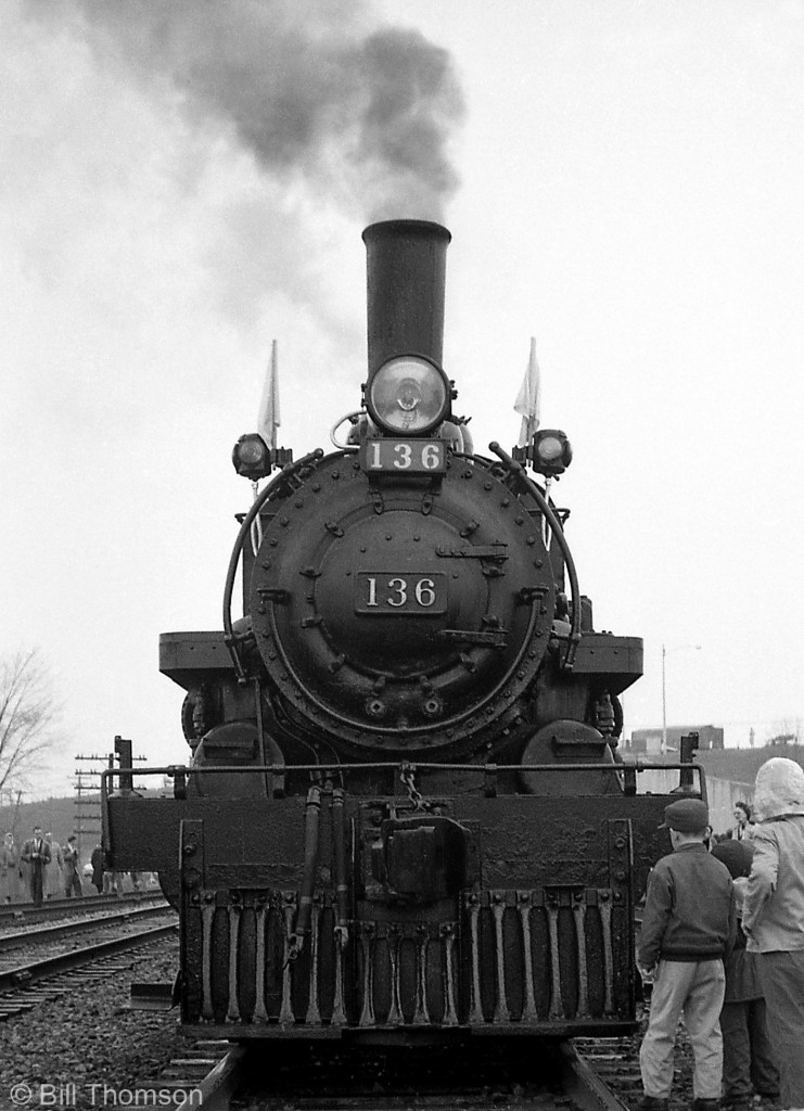 Young and old passengers, some bearing cameras to capture the scene, crowd around the front of CPR 4-4-0 136 stopped near the station in Cooksville on April 30th 1960. The day before the famous tripleheader on May 1st, CPR 136 and 815 ran together on a shorter Toronto-Cooksville fantrip along the Galt Sub.