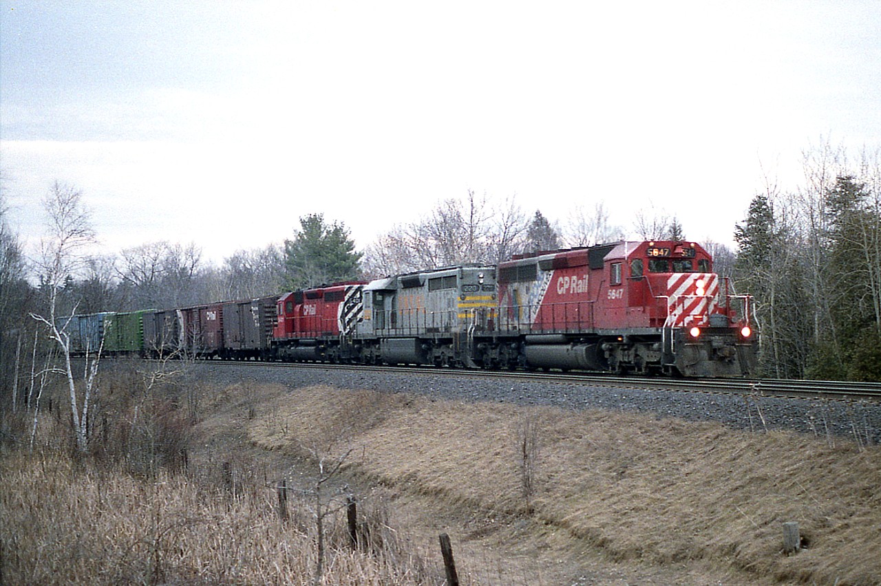 The light was up and I kept waiting, getting worried it would be dark before a train showed up, as the day was drawing to a close. Not an easy shot with an old camera with 100ISO print film in it. Anyway, it showed in time; westbound just about approaching the Campbellville Rd crossing west of the village in this view; CP 5647 (EXPO 86 Scheme), QNSL 220 and CP 5401, which was formerly QNSL 205).