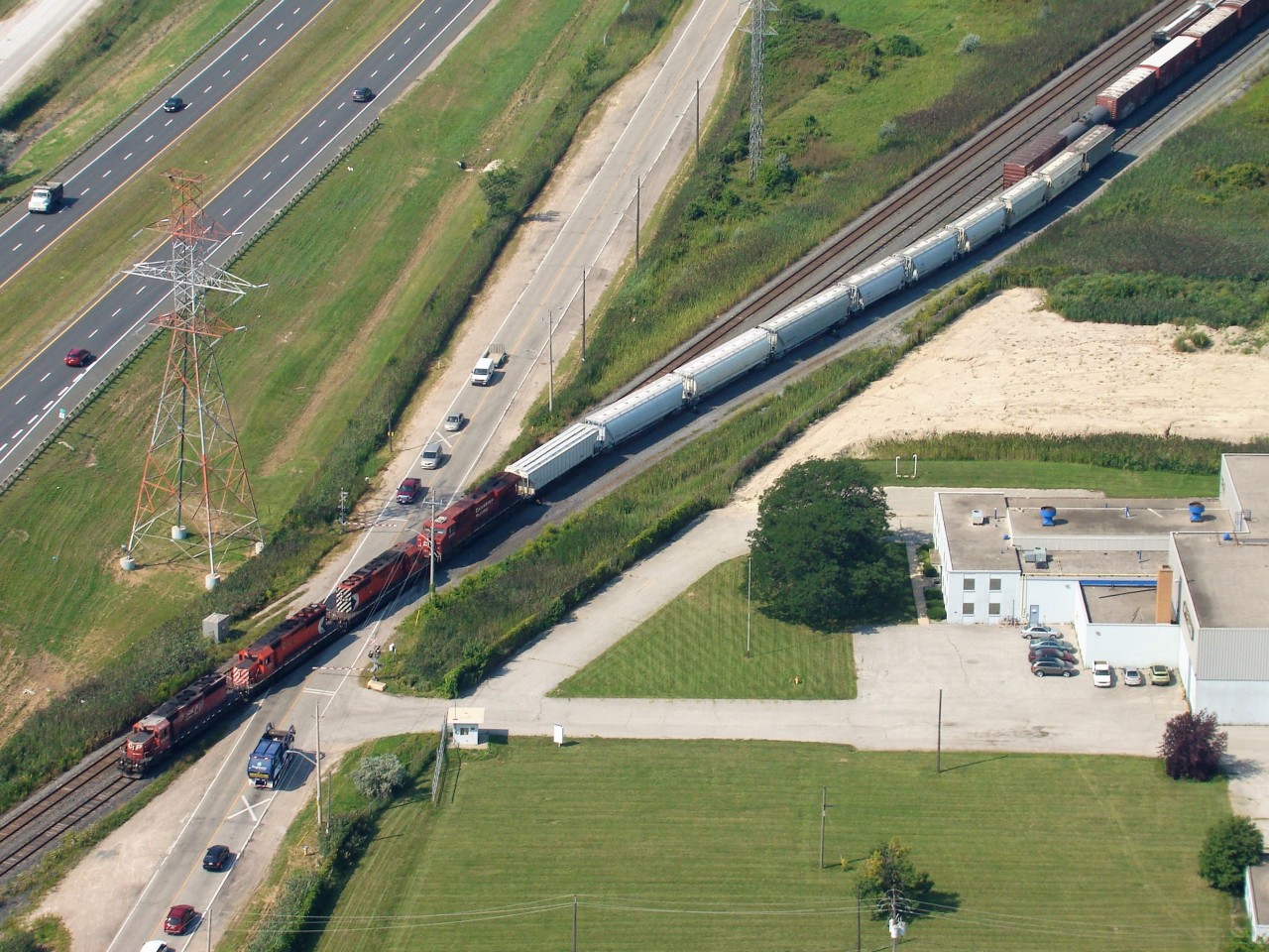 Three SD40-2's and an ES44 switch Walkerville Yard on a hot summer morning as seen from the sky before landing at Windsor Airport. The E.C. Row Expwy is at left with North Service Rd. being blocked by the train.