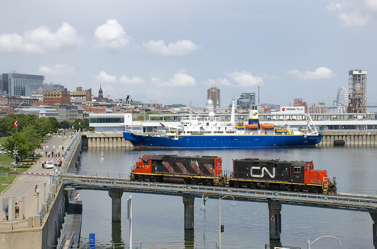 CN 7054 & CN 4707 are entering the port light power to pick up some cars in interchange from the Port of Montreal. In the background is the cable ship IT Intrepid.