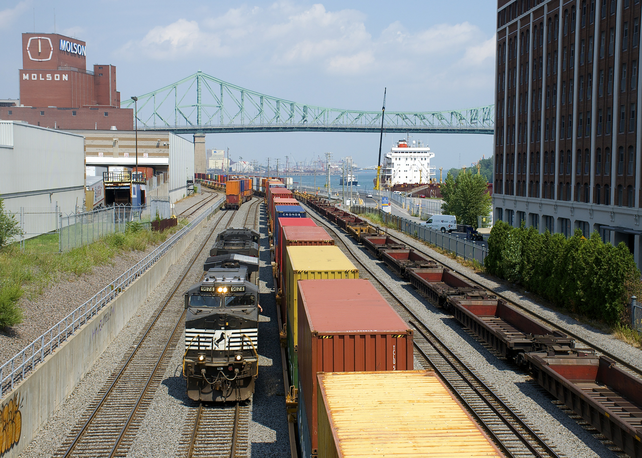 CN 543 (with NS 9674 & UP 8972 for power) has brought a long string of baretables into the Port of Montreal (seen at right) and is about to couple onto the double stacks in the middle of the frame before heading west. At left is the venerable Molson Brewery, which is supposed to close in the near future, with the Brewery moving to the south shore and in the distance is the Jacques-Cartier Bridge. Finally at right the Oakglen is docked and further to the right is what was once a cold storage building, but is now condominiums.