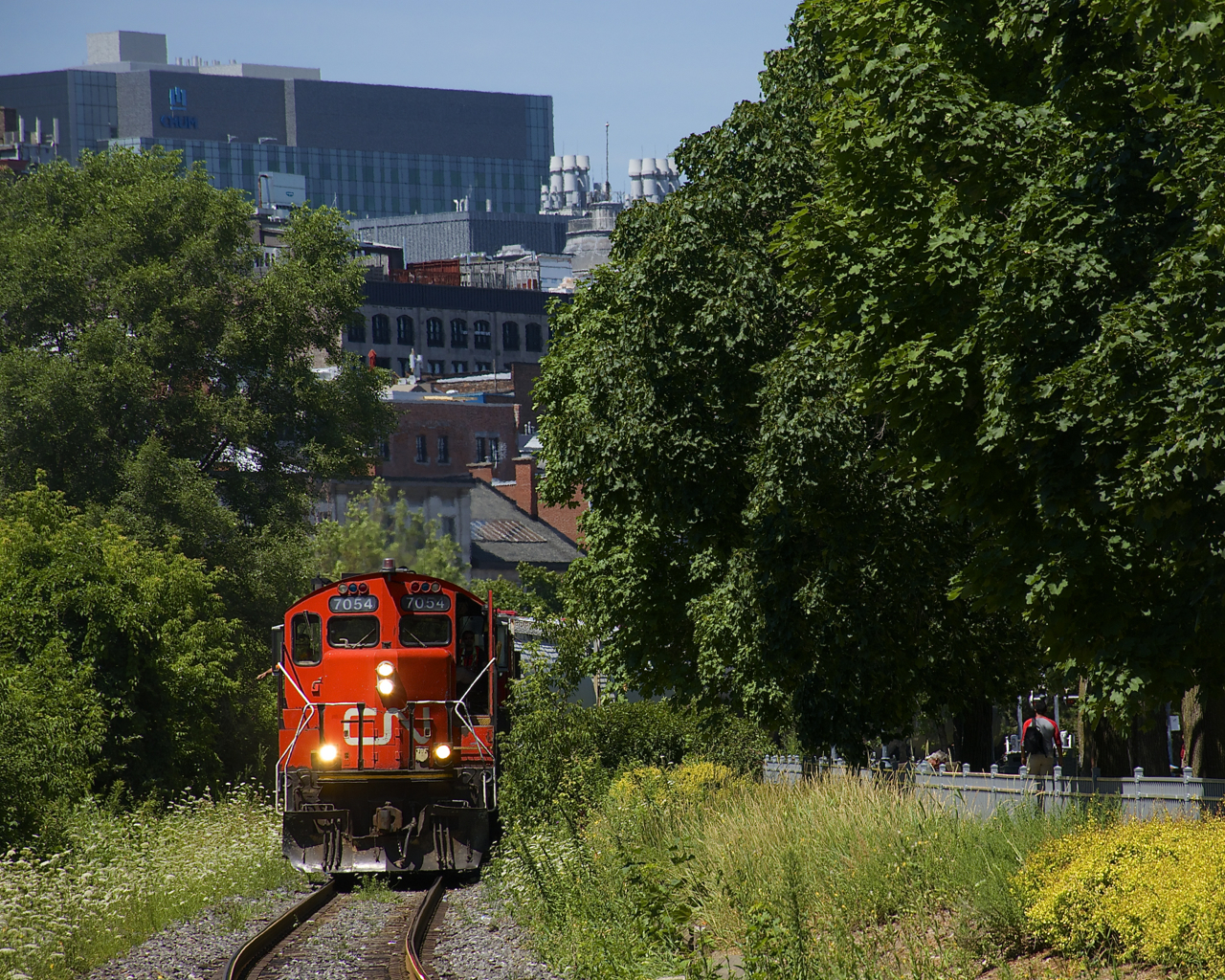 The Pointe St-Charles Switcher is leaving the Port of Montreal with nine cars and CN 7054 & CN 4707 for power as it rounds a curve.