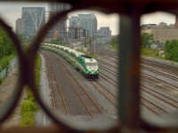 An inbound GO train for Union Station rolls along the Union Station Rail Corridor coming off the Oakville Sub.  The train is about to pass beneath the ancient Bathurst Street bridge, a local landmark in Rail history.  The bridge, built in 1903 (used elsewhere, then moved to it's current location in 1916) has spanned the CNR and CPR tracks for over a century.  The rust veiled, riveted steel has seen it all; the glory days of steam, streamlined passenger trains, Cabin D interlocking (with  CPR Tecumseh Stret interlocking just behind) for the Toronto Terminals Railway/CNR Oakville Sub/CPR Galt Sub/CNR Brampton (later Weston) Sub, the landmark Inglis sign, a simpler time.  Now the hustle and bustle has overtaken, the Weston Sub, Galt Sub south of West Toronto and Oakville east of Burlington West now owned by Metrolinx, the majority of rails in the downtown lifted to make way for development, the Inglis sign, removed in 2014, everything has changed.  As for the bridge, almost all of it dates to 1916, some from 1931 when it was improved, and the railings above from 1997.  Bathurst Bridge stands the test of time and surely will for some time.  It's nice to know with progress always marching sometimes history holds true.