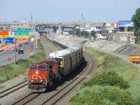  A 444-axle CN 401 is approaching Turcot West with a couple of strings of TankTrain cars behind the usual head end autoracks. The right of way it is traveling on (CN's Montreal Sub) is supposed to be taken out of service by the end of the month, replaced by a brand new line slightly further north. To the right of the train are the remains of what were once the westbound lanes of autoroute 20, now also shifted further north.