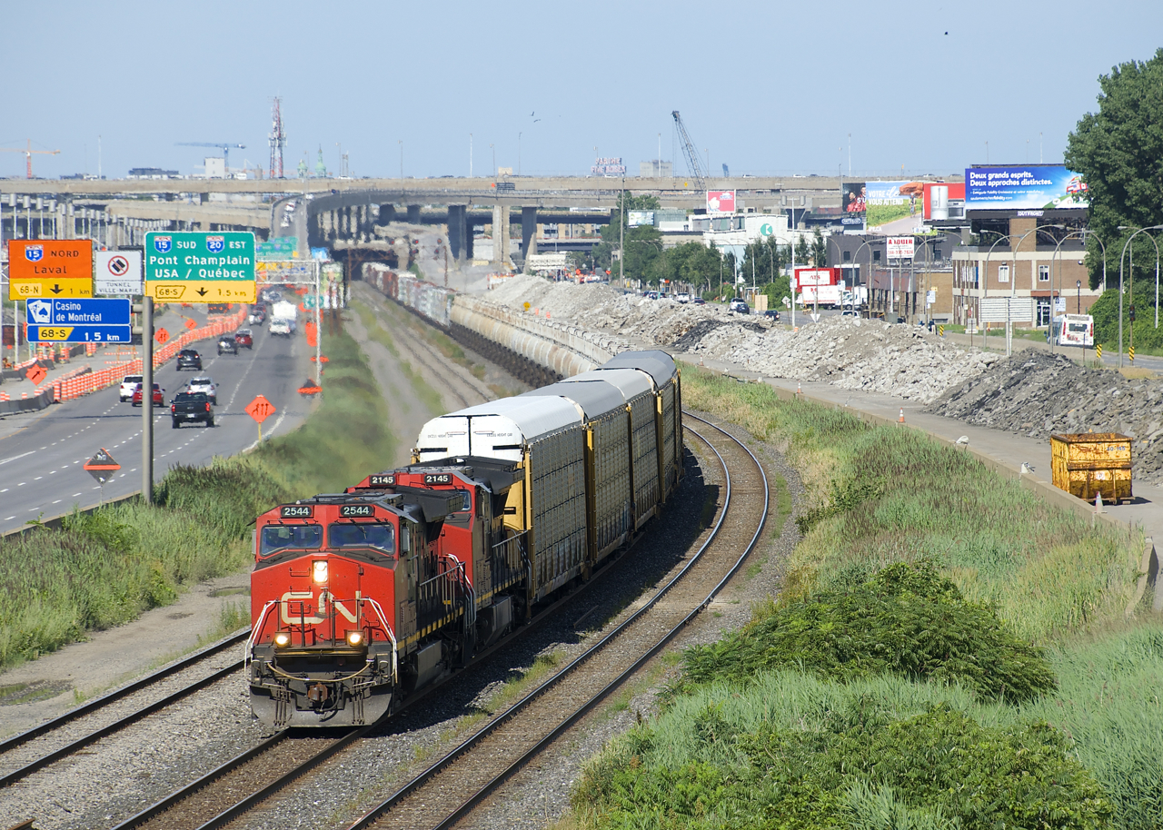 A 444-axle CN 401 is approaching Turcot West with a couple of strings of TankTrain cars behind the usual head end autoracks. The right of way it is traveling on (CN's Montreal Sub) is supposed to be taken out of service by the end of the month, replaced by a brand new line slightly further north. To the right of the train are the remains of what were once the westbound lanes of autoroute 20, now also shifted further north.