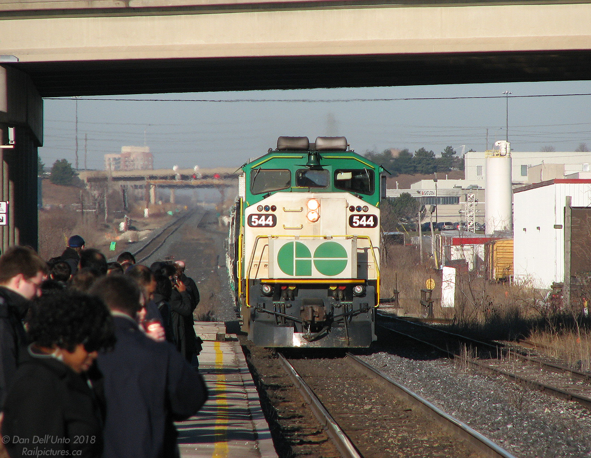 It's 8:04am and the usual crowd of Bramalea commuters, sipping their morning coffees and chatting on their cellphones, have all shuffled from the south side of the platform to the north side as GO Transit F59PH 544 leads train #210 (the final morning train from Georgetown, running on time) under Steeles Avenue overpass and into Bramalea GO station, with ditch lights dimmed and bell ringing. Everyone would soon pile on in the usual "semi-orderly" fashion, grab what free seats were still available (sorry Malton and Etobicoke commuters, you get to stand!) and settle in for the ~30 minute ride to another day in downtown Toronto.

Everyone always crowded the south side of the platform as usual morning practice was for the CN RTC to run the GO's on the south track between Peel and Halwest, giving them a straight shot onto the Weston Sub (judging from the work flags there may have been track work going on along the south that morning). GO 544 is on the "old" north main track, today the #2 main after the GO triple-tracking upgrade was completed. The north service track is visible next to it (present-day #1 main track), with switches to the Torbram Industrial Lead and Lipton Lead visible (I spy two boxcars spotted at Robert Transport). In the distance the CN Halton Sub climbs to the downtown Brampton area, with West Dr. and Highway 410 overpasses visible beyond the old signalbridge.