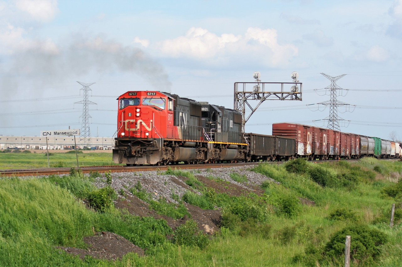 An eastbound CN train with SD75I 5717 and IC SD70 1021 is seen departing Mansewood on the CN Halton Subdivision, just east of Milton, Ontario after meeting a westbound train with SD40-2(W)’s 5260 and 5331.