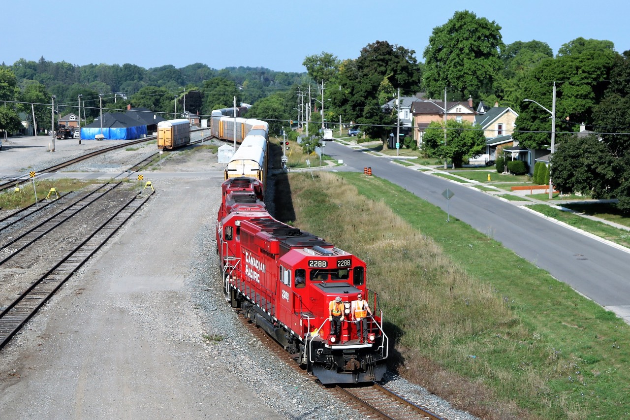 After working in the Galt Yard, CP 2288 leads a long auto rack manifest train along Samuelson Street headed to the Toyota Plant. Extensive renovations to the old Galt train station are visible. Built in 1898, it is in the process of being brought back as close to original as possible as it is deemed an historic building. The maintenance shed is wrapped in the blue tarp.