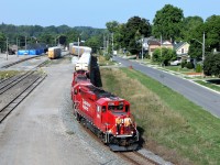 After working in the Galt Yard, CP 2288 leads a long auto rack manifest train along Samuelson Street headed to the Toyota Plant. Extensive renovations to the old Galt train station are visible. Built in 1898, it is in the process of being brought back as close to original as possible as it is deemed an historic building. The maintenance shed is wrapped in the blue tarp.