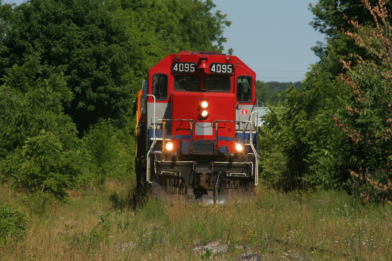 Goderich-Exeter Railway (GEXR) train 518 is traversing the seldom used portion of the Fergus Spur through Cambridge, Ontario as it slowly heads towards the Concession Road crossing and the Babcock & Wilcox facility to lift a substantial load. The light power includes; RLK GP40 4095 and GEXR GP39-2u 2303.