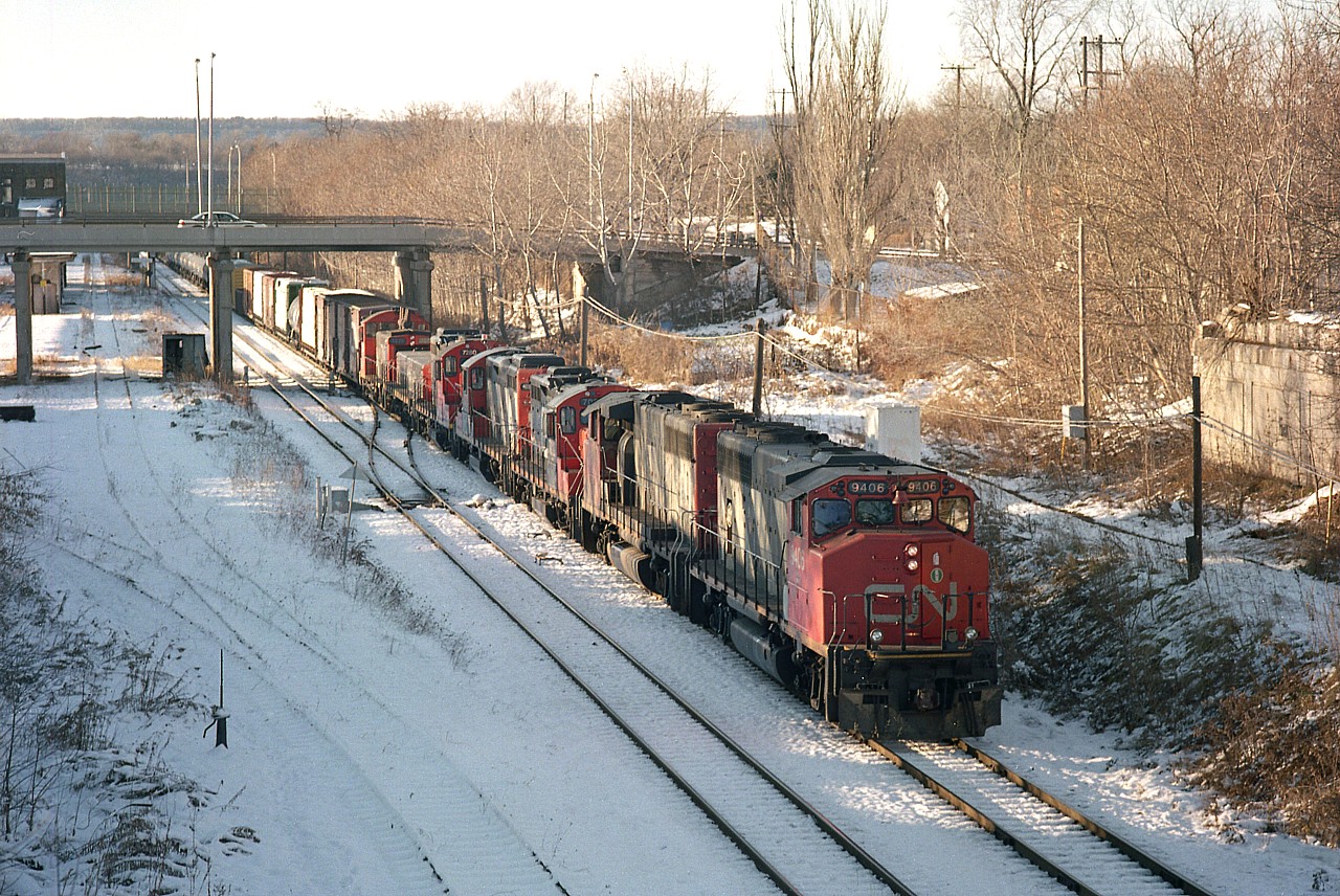 RaiLink Southern Ontario took over the old CN Stuart St yard on Dec 15, 1997. So, this image is of the last of the CN presence leaving town the day before. The 'end of the line' resulted in CN 7027, 7127, 7280, slug280,and 1371 as well as a lot of freight cars being lifted by #449's CN 9406 and 9513 and being shuffled off to Niagara Falls to make it a clean start for RaiLink. It wasn't long, about a year when RailAmerica took over, and then Genesee Wyoming Canada moved in and after only 6 years the yard is rumoured to be reverting back to CN in mid-December 2018, 21 years less a day since this photo from the John St. N was taken.
On the right is the support structure for the old Hughson St bridge and in behind, James St N overpass. Left is part of the old CN Station complex and needless to say this area has completely undergone change since the West Harbour GO station has been constructed beyond James N bridge, on the left side.