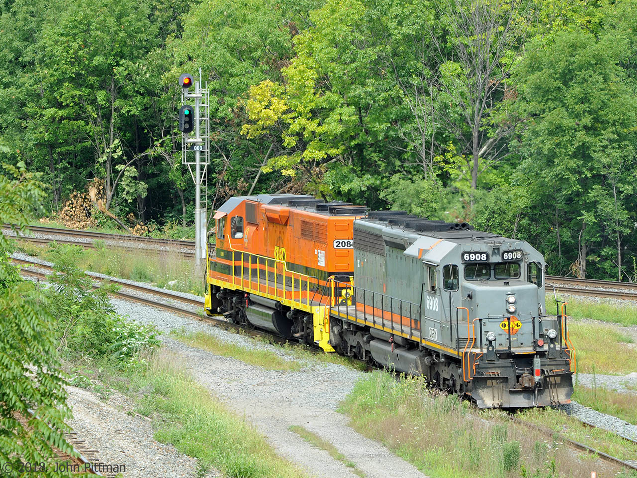 Southern Ontario Railway light power is en route from Hamilton to Brantford, seen here with a bit of Cowpath grass.  The signal indicates proceed, with switches lined for the south track of the Dundas Sub. CP's Hamilton Sub be seen between the Sumach leaves in the bottom left corner.
QGRY 6908 is an SD40-3, an Alstom rebuild of SD40 CN 5198. It emerged from rebuild as GCFX 6038, after that it became WC 6908. QGRY 6908 is carrying an SBU. It may qualify for the no-bell prize - unless it's tucked away somewhere out of sight.