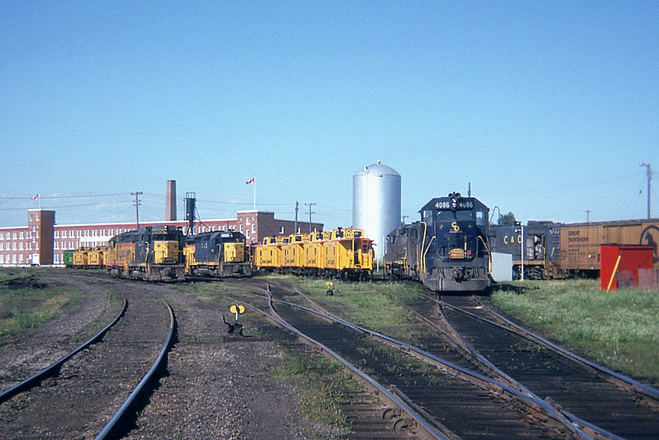 This is what it looked like in the 'glory' days for the railfans. The sprawling Chessie facilities at St. Thomas, as seen 44 years ago last month as of this posting. All gone now. Just empty shells of the past in an empty field. Lots of power and plenty of cabeese to be seen too. The green one on the end I think was a special Safety paint job. Someone in the know can enlighten us. Canadian flags overhead give this overall scene a nice touch.