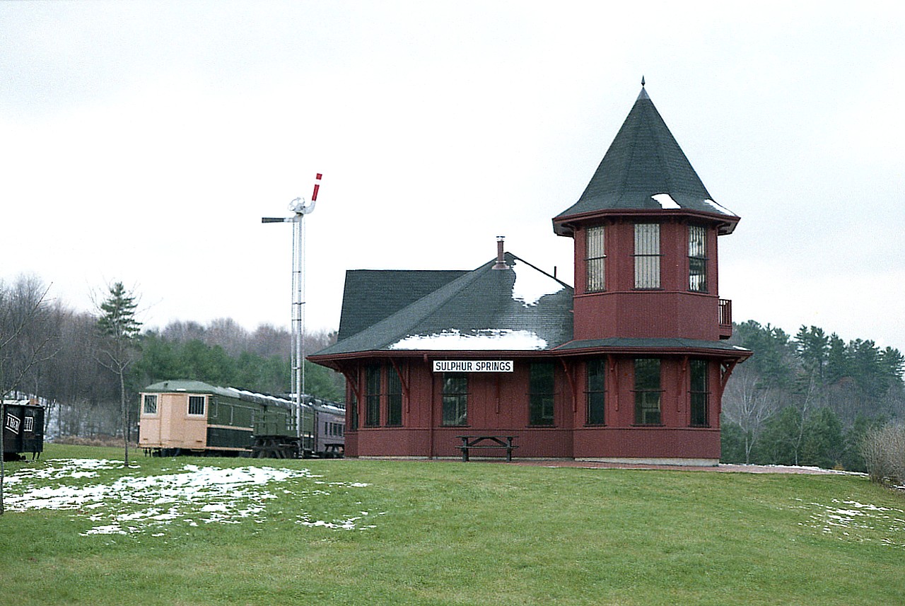 Station looks real, but it is a replica. The name seems real, but it is fictional. In actuality this newly built Victorian style building houses the Visitor's Centre in the Dundas Conservation Area off Governor's Rd in Dundas.  This is a park most railfans notice as they are roaring up to Copetown en route to catch some train. Next to the station on the left is the remains of what was once a spur off the TH&B Waterford Sub which passed this structure on the right. All there is now is enough rail to house this old CN Oil-Electric unit (privately owned) and according to CTG an X-CP coach in behind. Also on the property is an old iron Crossbuck, looking pretty good.....probably repainted many times.:o)
Sulphur Springs "station" is relatively unknown due to its' location and low publicity, but it has been photographed many times, having shown up in movie props and a few commercials over the years. The whole area makes for a very interesting visit.