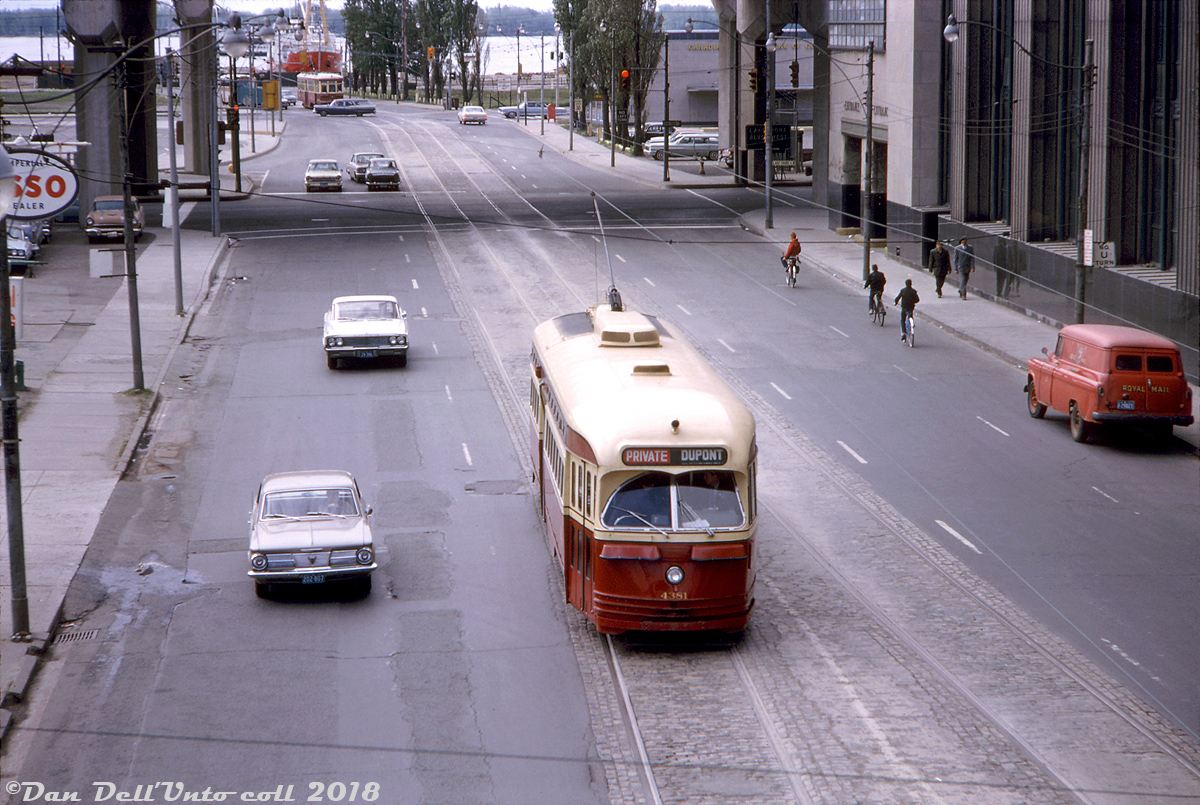 Shiny TTC A6-class PCC 4381 heads northbound on Bay Street above Lake Shore Blvd., just about to duck under the Union Station rail viaduct during an overcast Saturday fantrip. Her route rollsign is displaying "Dupont" for the old Dupont streetcar route that used to run up Bay until the University subway line opened in February 1963 (the tracks here remained on Bay for seasonal Ferry Docks service until discontinued later in 1965). 
Also chartered for the fantrip was Peter Witt streetcar 2766, visible in the distance stopped for traffic at Harbour Street.  In contrast to the spit and polish look of 4381, 2766 was looking rather ratty by that time as what few Witts remained had already been retired earlier that year except 2766, which would run a few more fantrips until being retired in July (later brought back in the 70's and overhauled for tour tram service).

Notable landmarks pictured include the Toronto Postal Delivery Building (now the site of the Air Canada Centre) with a red Royal Mail Canada delivery truck parked out front, the concrete supports of the Gardiner Expressway, a slight lack of development along the waterfront (compared to today!), some cyclists on their merry way down Bay, and of course the usual assortment of 50's and 60's vintage auto content for those into that sort of thing...

John F. Bromley photo, Dan Dell'Unto collection slide.
