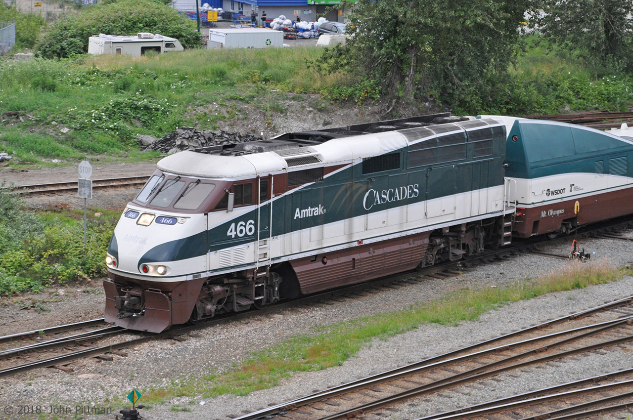Amtrak Cascades train 517, the 6:35am departure from Vancouver BC's Pacific Central station is leaving station track at Burrard Inlet Junction. Note the faded STOP sign for trains at this critical pair of switches. F59PHi AMTK 466 in the latest Amtrak Cascades scheme merges well with Talgo Pendular Series 6 coach set "Mt. Olympus".  
When Cascades trains began running with Talgo coach sets, an F59PHi was the usual type of locomotive on these trains. A similarly painted NPCU was typical at the other end for push-pull operation (NPCU = Non-Powered Control Unit, an ex-F40PH). As the F59PHi's accumulated mileage and aged their reliability decreased. Substitutions became common, sometimes with locomotives at both ends just-in-case. 
On this run AMTK 466 has been trusted as sole tractive power for the train. In late June 2018 the usual locomotive I saw on Amtrak Cascades trains in Vancouver was a new Siemens SC-44 Charger.