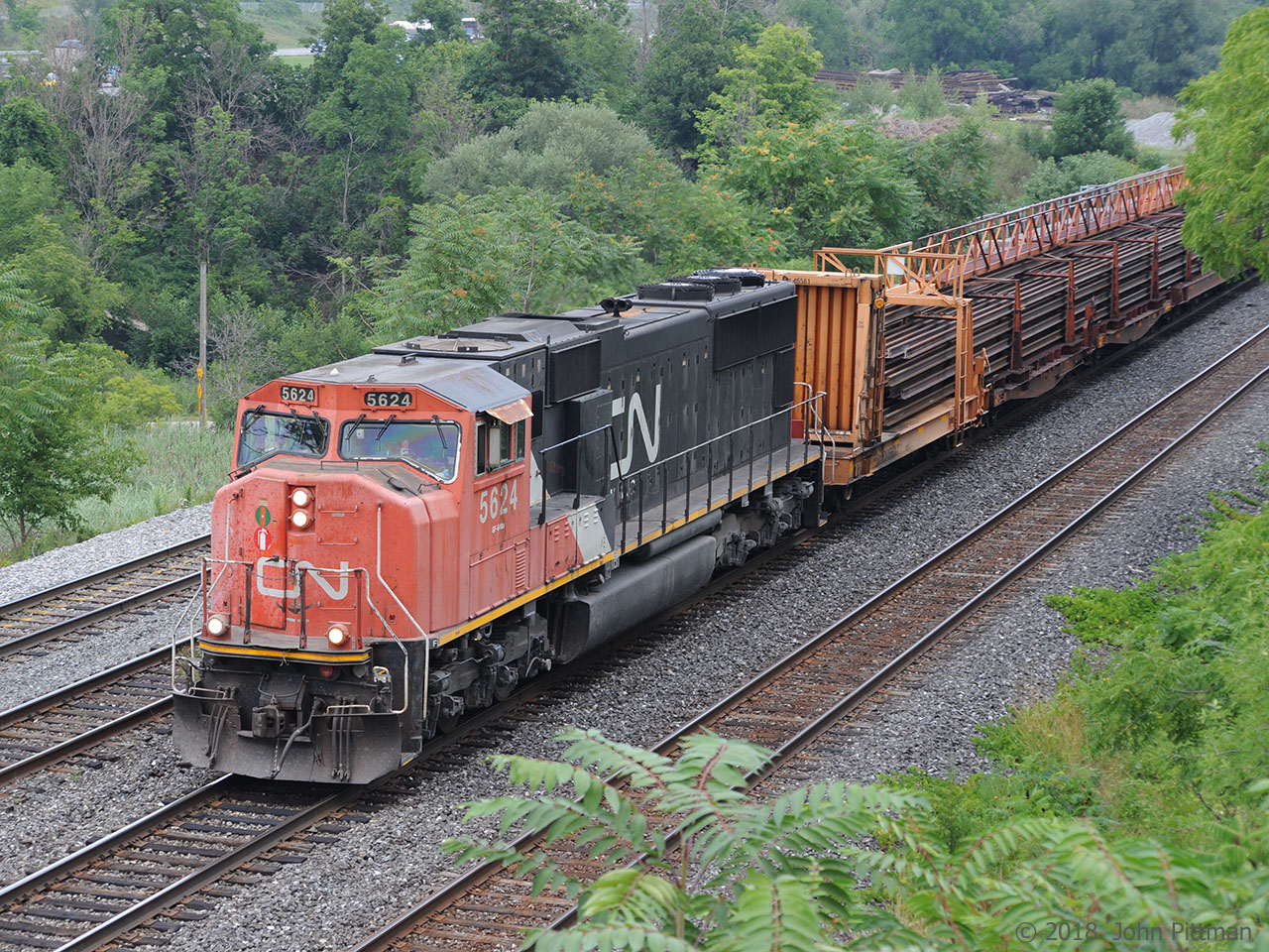 Continuous welded rail train powered by SD70i CN 5624 heads west on the Oakville Sub toward CN Snake.  The bulkhead rail carrier car behind the engine is CN 46561.