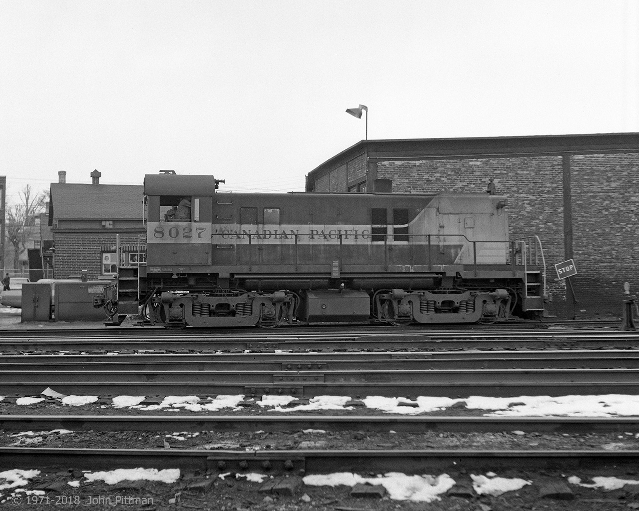 MLW RS-23 CP 8027 is seen here beside the Trois-Rivieres roundhouse in (approx) March 1971. In 1970-71 its siblings CP 8035 and 8040 were much more frequently seen here. The RS-23's did their yard switching singly, I never saw them MU'd in pairs. Alco S-2 switcher CP 7042 was another regular.  
No structure or tree visible beyond the tracks remains - the CP structures were all demolished, while the adjacent neighborhood was cleared to make way for Quebec Autoroute 40. Quebec Gatineau Railway serves T-R now.