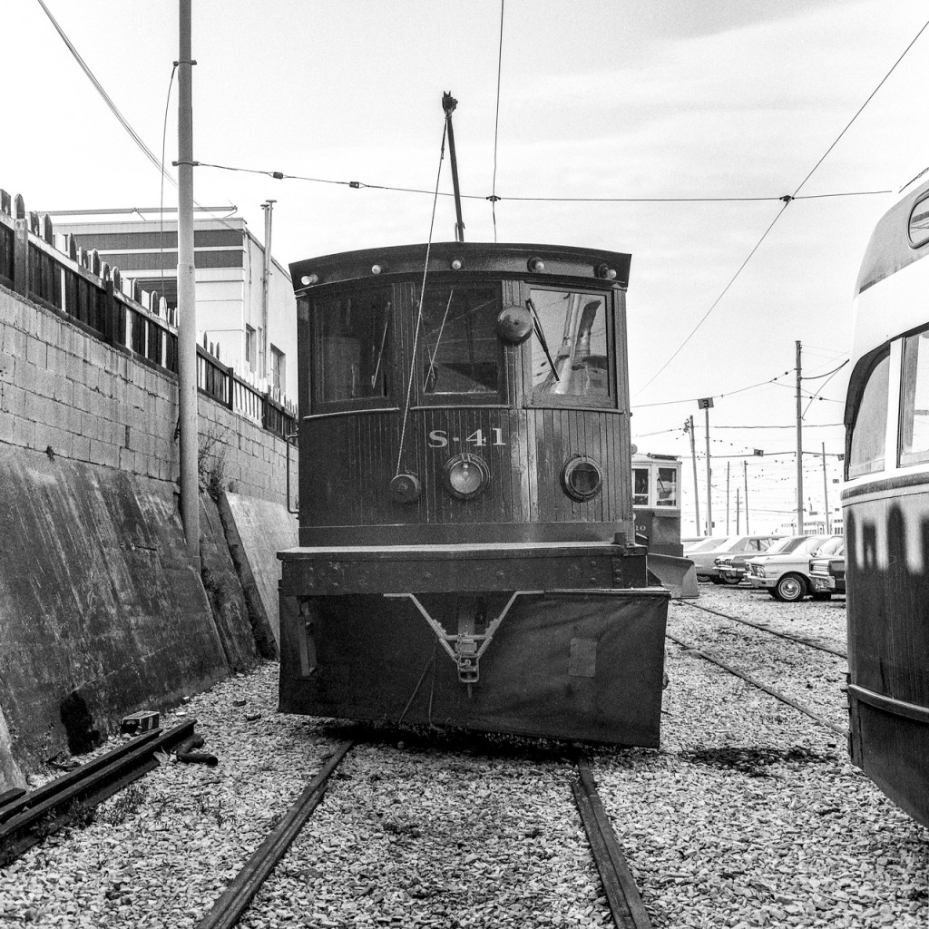TTC S-41 is a snow sweeper photographed in Toronto on September 13, 1969.
Yes, she leans to the left. Whether it is the trackage or S-41 herself, the wall of the building on the left is straight in a vertical direction. Looking at the gleam of her paint, she appears to be very well taken care of by TTC.