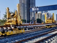 Absolutely amazing watching the process of rail replacement on the Oakville Sub at Humber.
The panel tracks for the approaches to the Humber are built off site, then loaded on these really cool remote controlled self propelled trolleys (8 in total). When the panel track is in position on the track next to the one being replaced, the robot gantries  that are sitting on top of the new rails put their arms down on to the ballast and lift the panel track up and off the dollies. Then the 8 trolleys are remotely removed from under the panel track. The gantries which can move vertically and horizontally now can move the panel track over towards the graded roadbed and set into place. Fascinating!!