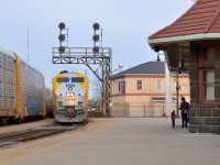 VIA 75 coasts beneath the antiquated cantilever signal at Brantford as it slows to a stop while CN 385 works the yard on the north track on a crisp spring evening.