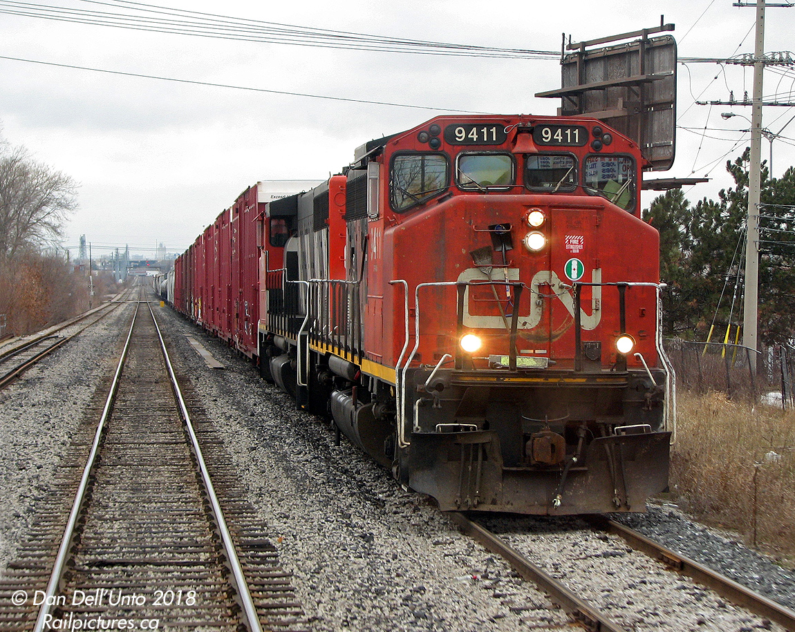 Meeting at Malton: After departing Bramalea GO station, our eastbound GO train on the main (#260, Bramalea-Union) overtakes CN #577 running along the north service track near Malton, which had departed Malport Yard not too long ago and is seen making its way down the Weston Sub to interchange traffic with CP at West Toronto. Even though we have two stops to make at Malton and Etobicoke North, our GO train will easy outpace #577, and it'll likely stay on the north service track until Woodbine East before taking the main and making a run for the CN-CP connecting track at West Toronto (CN Keele). CN #577's real treat was it usually pulled a pair of GP40-2LW's as power, which were becoming difficult to find at the time as CN's once mighty fleet of 278 units had been whittled down to just 60 or so, with many in need of an overhaul and new paint. Sister units 9411 (in ratty zebra stripes) and 9410 (in fresh zebra stripes) handle the usual CP-bound traffic, including a cut of red CP boxes at the head end. GP40-2LW 9410 was the prize unit to catch at the time: for some unknown reason it had been repainted in the long-dead zebra stripe livery at Transcona Shops almost a year earlier, and this fresh repaint was hanging around the Toronto area working freight and local assignments.

Even though Metrolinx had not yet bought the line, the local Weston Sub switcher (CN #579 IIRC) was a night job and the only other freight the line saw was #577 making its daily run down to West Toronto and back to interchange traffic with CP (MacMillan Yard via Malport to CP West Toronto and back). #577 usually ran in the afternoon as passenger traffic was at a minimum, with the exception of the afternoon GO "Bramalea Flip" runs which were easy enough to avoid. However if things got delayed, the CN RTC would have his work cut out for him trying to fit in #577 just before or during the PM GO rush and get it out of the way before anything got delayed (and things could get really FUBARed for Georgetown line commuters if it were to break down and stall on the single track section between Rexdale and West Toronto, which it occasionally did).