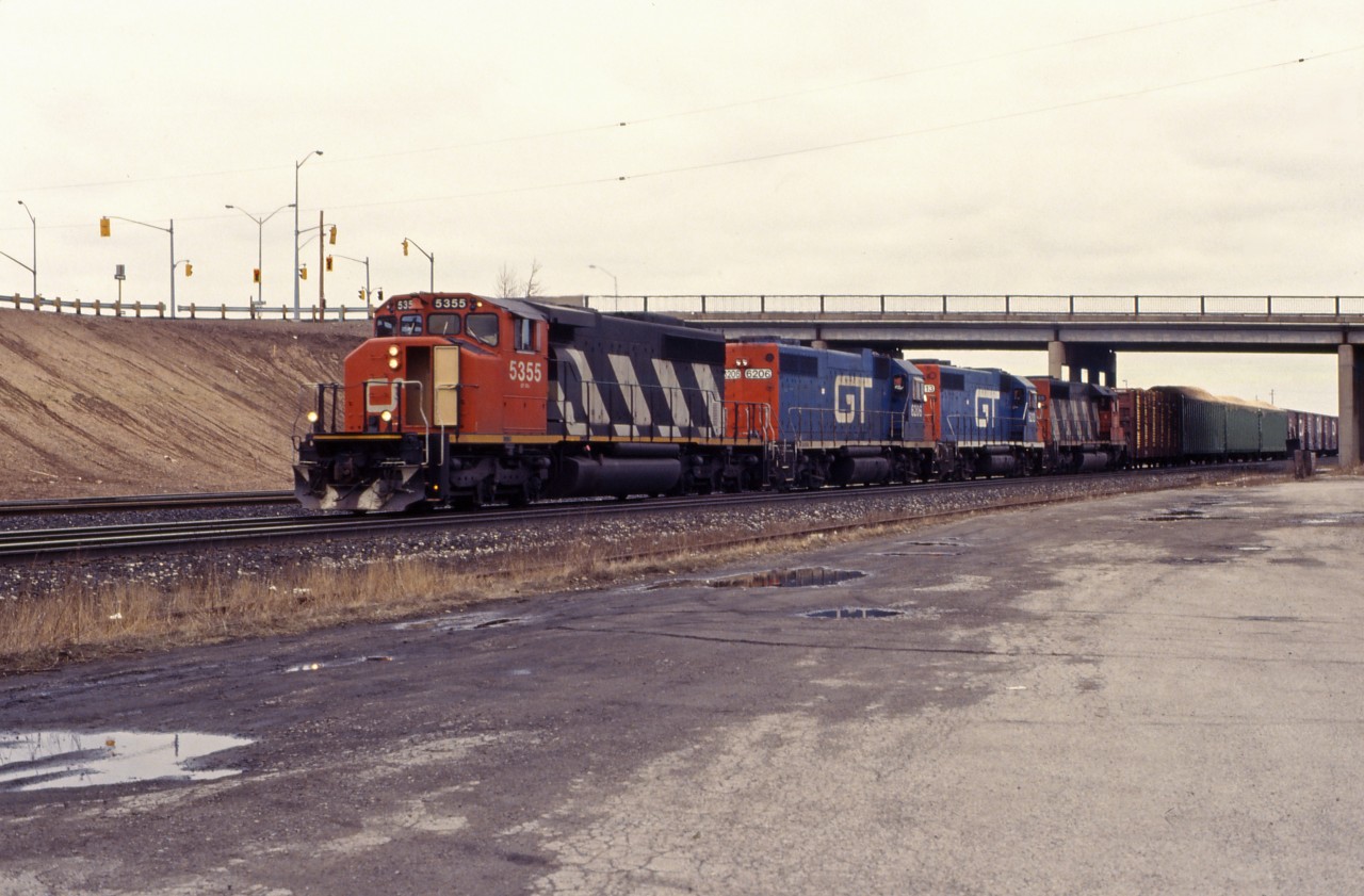 The road next to the cold storage in Aldershot used to be a fine place to get train pictures. You could get unobstructed shots without getting too close, and it was good for shots of trains working the yard as well as eastbounds and westbounds much of the day. Unfortunately, it is now fenced off...

But on this spring day back in 1994, I was fortunate enough to get this CN westbound (likely headed for Buffalo, with a Port Robinson set off) with some borrowed CN family power. At the time, former DT&I GP38ACs were common, while CN units were starting to operate in the U.S. on Central Vermont and Grand Trunk Western trains. Power is CN SD40-2W 5355, GTW GP38ACs 6206 and 6213, and CN SD40 5035.