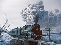 Heading towards Caledonia, CN 6218 fires a plume of steam and smoke into the cold winter air making for a spectacular display. The wind was in the right direction to carry the smoke away from the photographer's point of view.  This scene is crossing Fairchild Creek as seen from Old Onondaga Road part way between Brantford and Caledonia.  The bridge is now obscured by trees so this shot cannot be reproduced.  