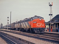 The dayshift operator at Burlington station, now called Burlington West, waves to the crew of CN 6520.  Note that this picture was taken before the grade separation at Brant Street was done.  The elevated gatekeeper's shanty can be seen on the left.  This area was originally called Freeman. The old Grand Trunk station is now preserved at a location about 500 hundred yards from its original location under the name of Burlington Junction. You can visit their website at <a href="http://www.freemanstation.ca"><b>Friends of Freeman Station</b></a>