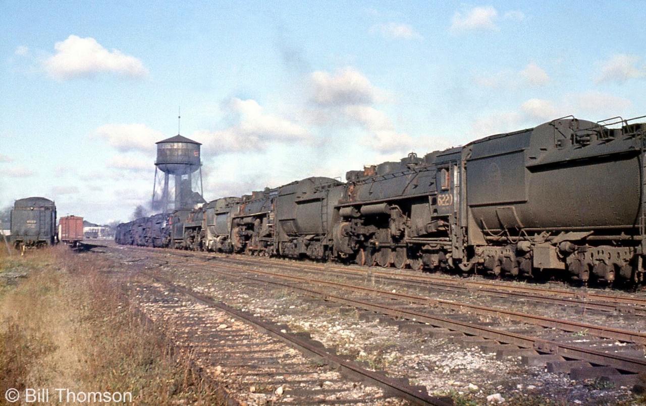 In a sad sight common during the end of the 1950's across the country, old steam engines that have rolled their last miles sit in the scrap line at Stratford in 1959, awaiting the inevitable fate of the scrapper's torch. Most appear to be U-series 4-8-4 "Northerns" (including 6220 closest to the camera, a U2g built by MLW in 1942), which were a larger model that was popular on CN in freight and passenger service.

To get an idea of just how compelling the efficiencies and benefits of dieselization were to railways, some of CN's newest Northerns built in 1944 were barely 15 years old when they were retired, relatively young for a steam engine. CP's newest Selkirks built in 1949 were retired at only 10 years of age.

While a few steam engines escaped the scrapper's torch via donation to museums, displays, sale to private groups or individuals and use in excursion service, the vast majority were unceremoniously cut up for scrap in the late 50's and early 60's. Stratford Shops, one of CN's major steam locomotive erecting backshops capable of overhauls and heavy repairs to the biggest of the big, was also closed at the end of the steam era.