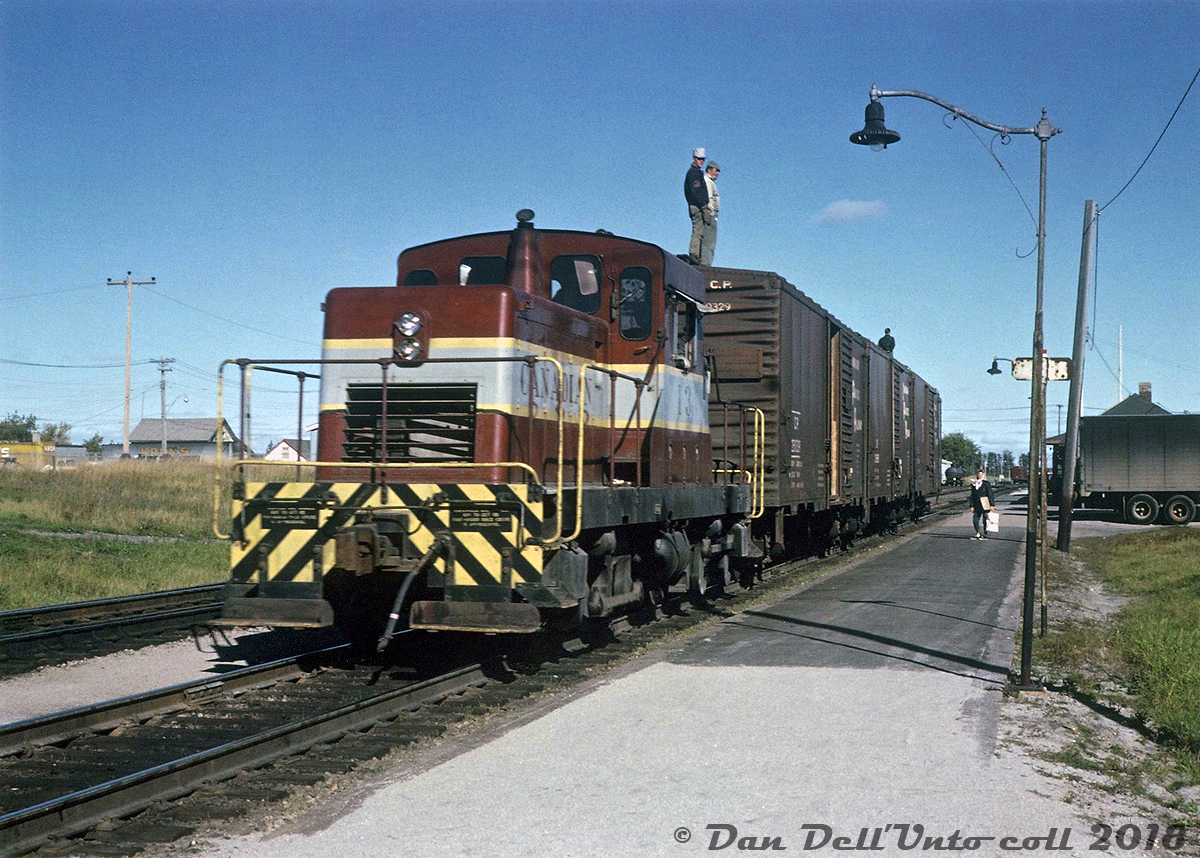 Canadian Pacific began purchasing little DTC (Diesel Torque Converter, sometimes called DT2's) units from the Canadian Locomotive Company in the late 50's to fill the role of a light switching locomotive that would qualify for operation without a fireman (less than 45 tons in weight). A typical switcher design with a center cab, thy featured two Caterpillar engines powering an axle on each truck via a torque converter, and power transmitted to the other truck axle via siderods. The 14 units were based at various locations across the system serving as light switchers for local assignments, branchline units on lines with weight restrictions (Chipman-Norton NB line, home of the final three famed 4-4-0's) and sometimes as shop switchers. The final order of DTC's in 1960 were some of the last locomotives ever made by CLC (with the exception of an industrial switcher or two), and CP's last order from the builder.

Shown here, CP DTC 13 is moving a short cut of 40' boxcars by the station in Dryden Ontario in 1964, with a number of crewmen riding the top running boards (aka roofwalks) of the 40'ers - regular practice back then but something that wouldn't pass the safety standards of today. These little units weren't able to handle many cars, and as freight cars increased in size and weight they were retired and sold off or scrapped. CP 13 was built in 1958 and originally assigned Vancouver, eventually being retired in 1969 at only 11 years old and sold off to Coleman Collieries. Other sister units lasted into the early/mid-70's before retirement.

J. Wollatt photo, Dan Dell'Unto collection.