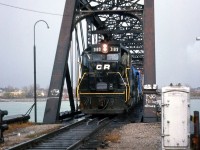 Conrail GP40 3189, still in patched Penn Central black, leads a repainted U25B on a freight crossing the International Bridge into Canada at Fort Erie, Ontario in November 1977.