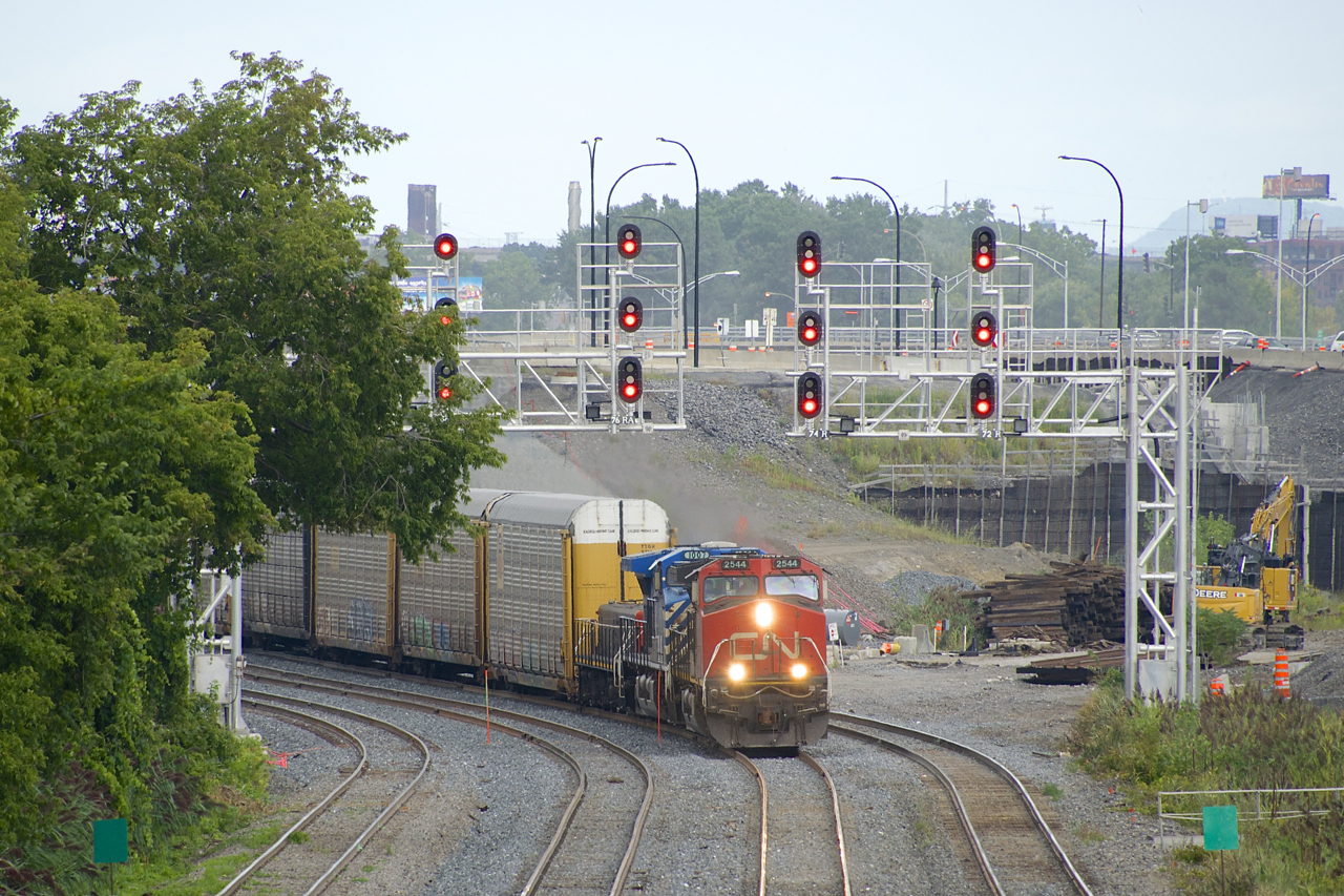 Since this past Monday, all VIA Rail and CN trains have been taking a new right-of-way between St-Henri and Turcot West In Montreal. A long time in coming, this new right-of-way was necessitated by the ongoing reconstruction of the Turcot interchange and nearby connecting highways. Here CN 401 is passing under a fairly new set of signal bridges as it curves from the left on the new right-of-way; the old right-of-way curved off to the right here (where the pile of ties are). Power on CN 401 is CN 2544, CEFX 1007 & CN 227.