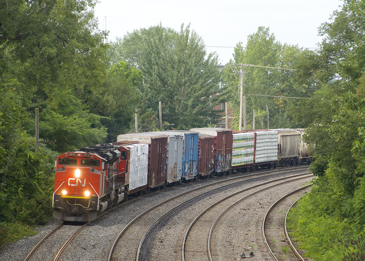 A pair of SD70M-2's (CN 8879 & CN 8916) have 83 cars for interchange to the NECR in tow (81 of them loads) as CN 324 rounds a curve on CN's Montreal Sub.
