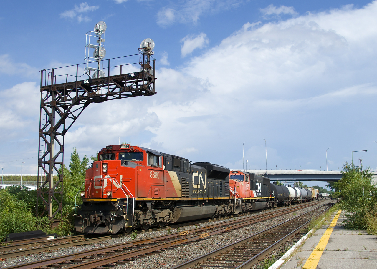 SD70M-2 CN 8880 and very faded CN 5722 lead a 133-car CN 377 through Dorval Station. While it was sunny when this train passed, it would soon darken and it was pouring 15 minutes later.