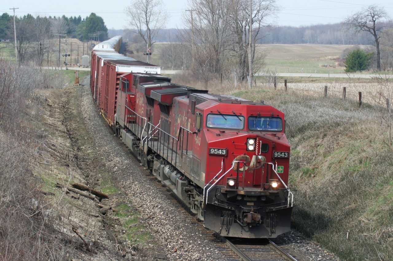 An eastbound Canadian Pacific train, led by a pair of AC4400CW’s in their as built duel flags paint scheme, is seen at the Highway #2 crossing, west of Woodstock, Ontario on the Galt Subdivision.