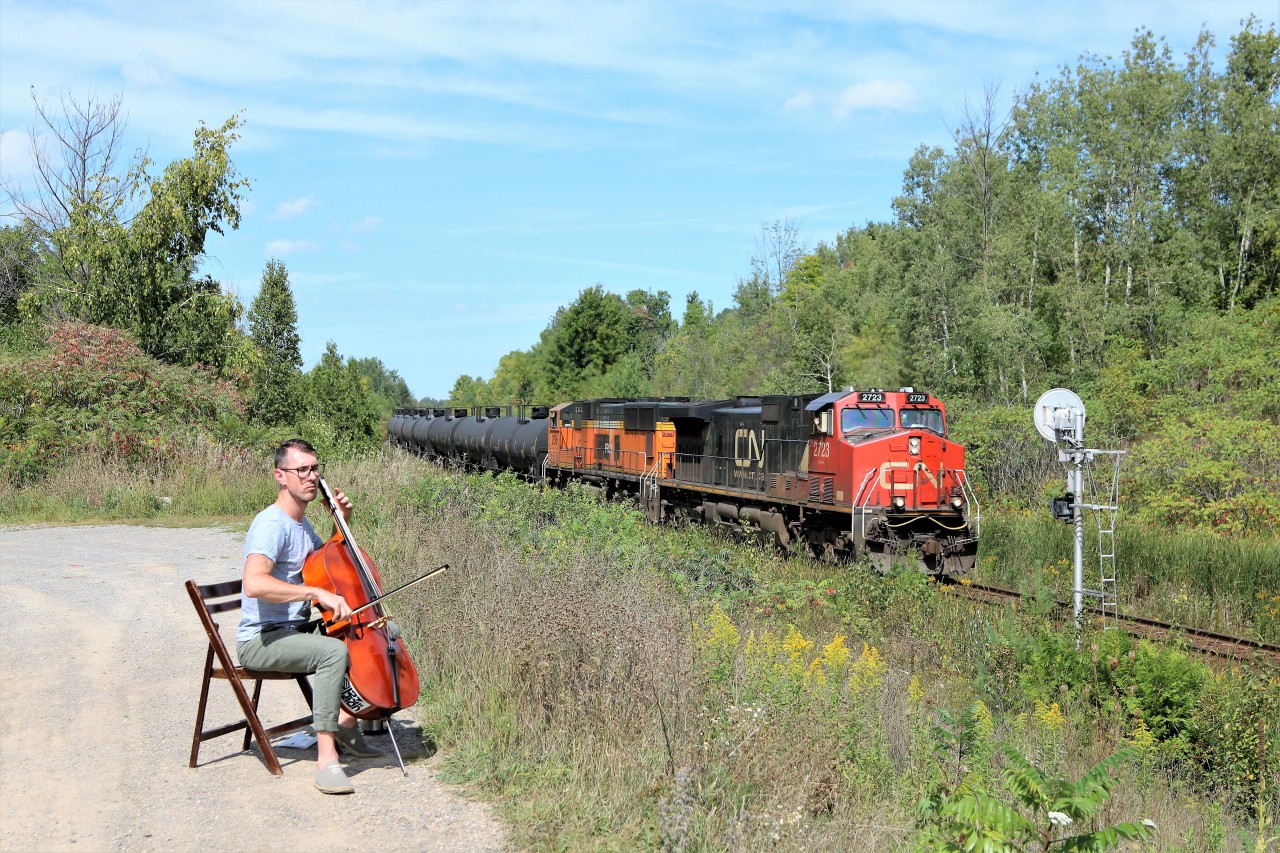 Well now, here's something you won't see every day. A very nice gentleman named John was practicing his Cello to the sounds of the rails as CN 2723 with PRLX 236 hauling tank cars rolled on by mile 30 on the Halton sub. Midway through the train CN 8849 with the track rail train was getting a lift.