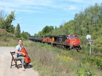 Well now, here's something you won't see every day. A very nice gentleman named John was practicing his Cello to the sounds of the rails as CN 2723 with PRLX 236 hauling tank cars rolled on by mile 30 on the Halton sub. Midway through the train CN 8849 with the track rail train was getting a lift. 