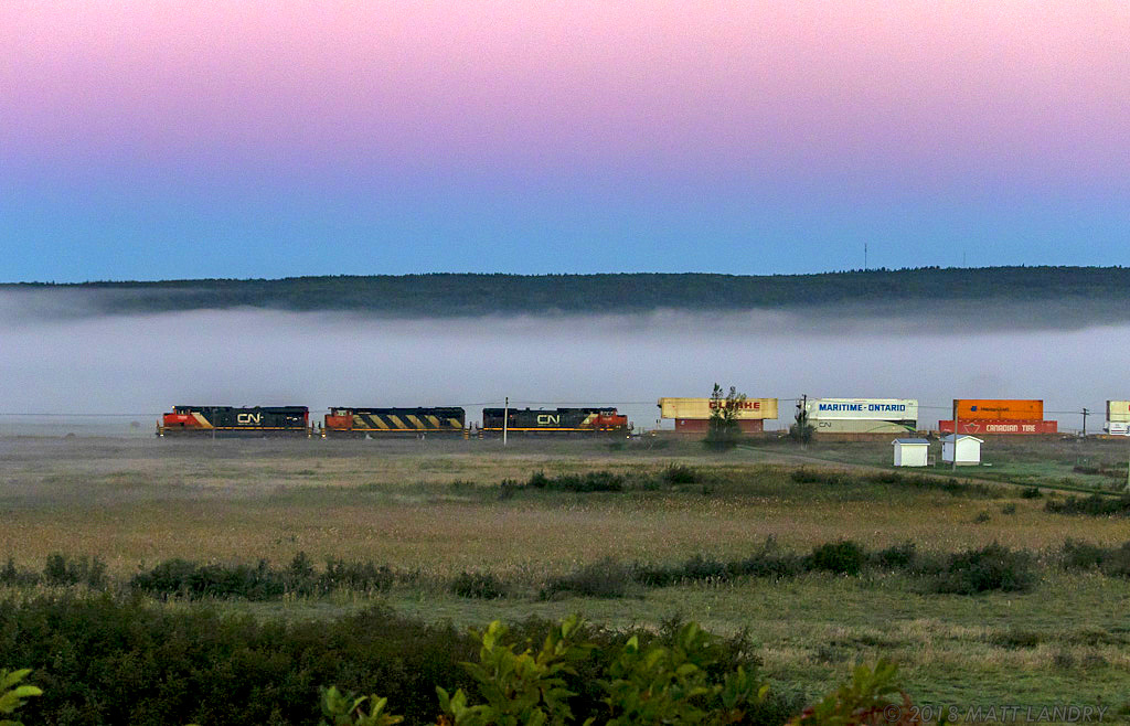 CN 2958 leads stacker train Q120, approaching Dorchester, New Brunswick, at sunrise.