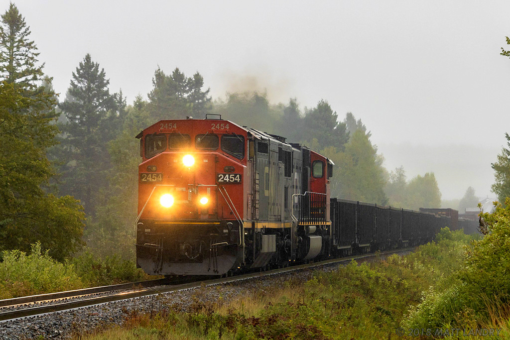HAPPY RETIREMENT! On a rainy Wednesday, westbound train 406 heads through Passekeag, New Brunswick, with a small train in tow. Engineer Warman, aka, "Pappy" is making his last trip, retiring after 40+ years of working on the railroad. Best of luck, and enjoy retirement!