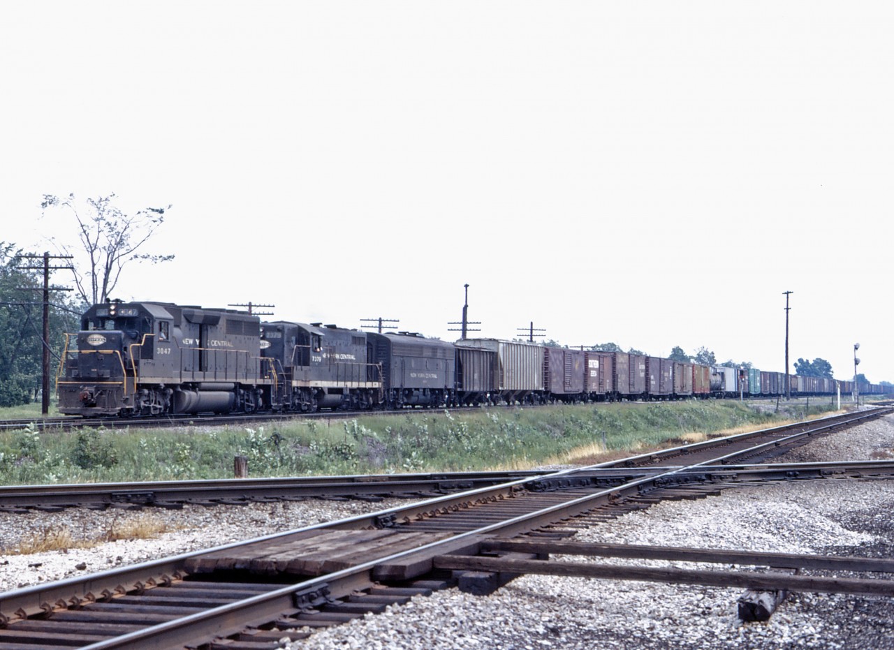 Although the Penn Central merger finally took effect on 1 February 1968, you could still see solid lash-ups of NYC power on the Canada Division for the first year or two. In this shot from Penn Centrals first summer, we see GP40 3047, GP 7379, and an unidentified F7B lead a train westward.