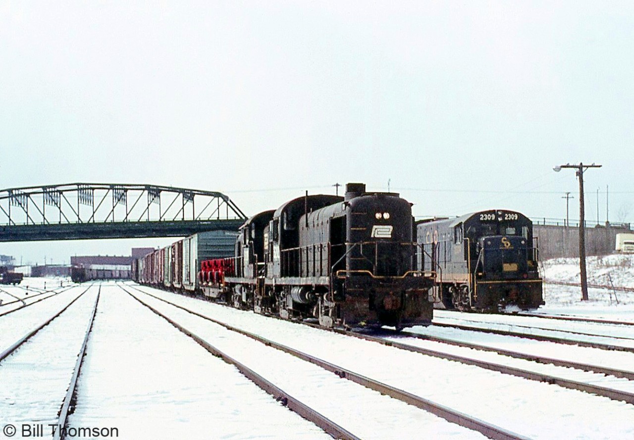 Penn Central RS3 5282 heads up a freight ready to head into the US, with Chesapeake and Ohio U23B 2309 sitting in the background near the old Central Avenue bridge on a snowy day in Fort Erie.