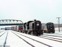 Penn Central RS3 5282 heads up a freight ready to head into the US, with Chesapeake and Ohio U23B 2309 sitting in the background near the old Central Avenue bridge on a snowy day in Fort Erie.

