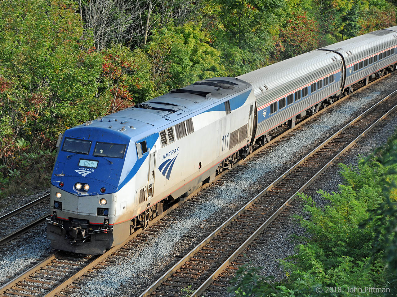Train VIA 97 (= Amtrak train 64) lead by AMTK 111 (P42dc) with Metroliner coaches is between control points CN Snake and CN Bayview, close to Bayview Jct T2 and T3 signals for westbounds.  Early autumn leaf colour is starting to appear.