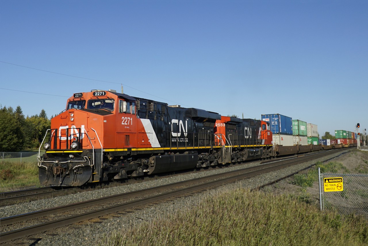 ES44DC CN 2271 and Dash9-44CW CN 2553 head an eastbound intermodal onto the south track at Ardrossan.