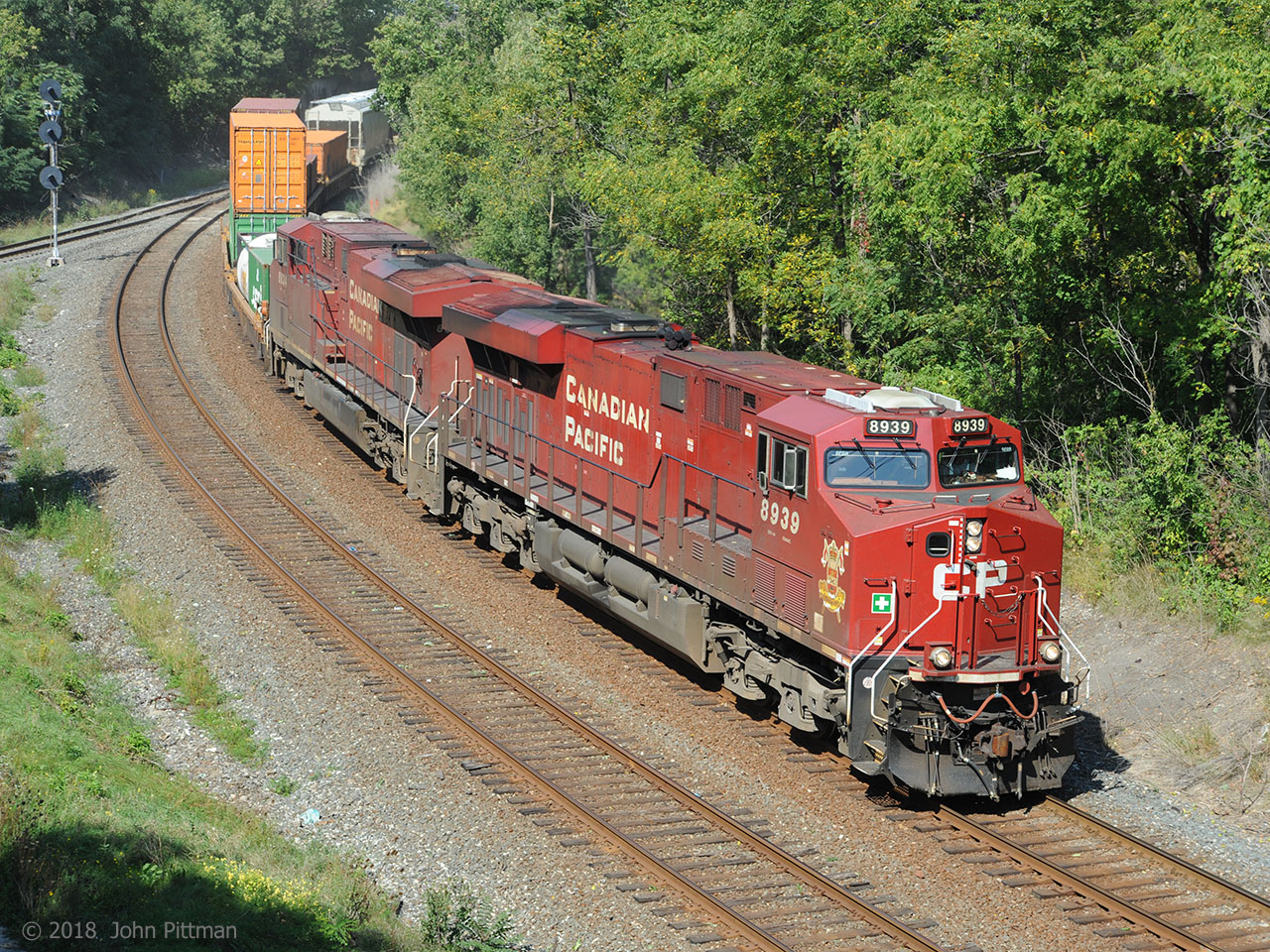 CP 8939 (ES44ac) displays the name Strathcona and emblem of a Canadian Armed Forces Regiment, Lord Strathcona's Horse (Royal Canadians).  Assisted by CP 8834 (AC4400), train 246 is southbound on the east main track of the CP Hamilton sub alongside the Aberdeen wye, heading toward the Hunter Street tunnel.  
Scottish-born Canadian businessman Donald Smith, 1st Baron Strathcona and Mount Royal, was co-founder of the Canadian Pacific Railway and the man who drove CP's last spike. A man of many interests and talents, in 1900 at his own expense he raised and equipped "Strathcona's Horse" for service in the South African War. CP has a continuing connection with the regiment. 
Strathcona as a street, town, or district name exists in multiple places in Canada, including the northwest Hamilton neighbourhood that the front of train 246 has just passed out of.