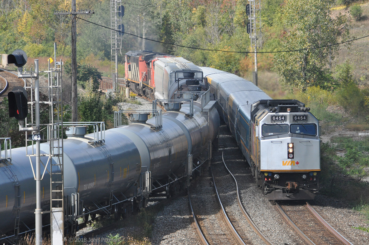 VIA 6454 is one of the few F40PH-3 that wear VIA's 40th anniversary colour scheme (ex Canada 150). It leads VIA train 72 eastbound at the west end of the Bayview Junction wye. 
Meanwhile CN train 331, powered by CN 2413 (Dash 8-40CM draper taper cowl) and CN 2157 (Dash 8-40CW, ex-BNSF), after interchanging cars at Hamilton Stuart Street Yard is departing the Cowpath west onto the Dundas Sub south track.