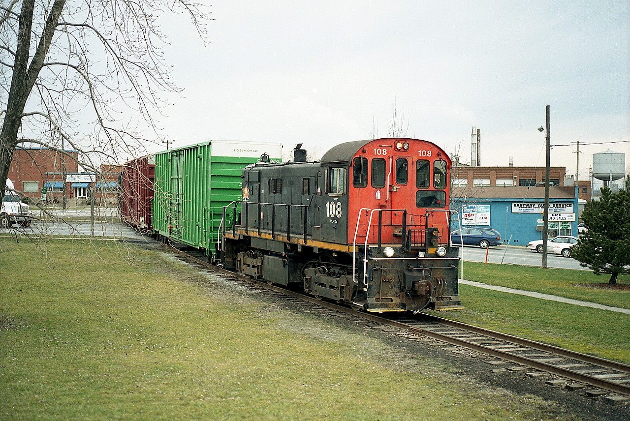 At first glance this scene might be a little confusing to the locals who view it. This train is crossing Glendale Av at Merritt St. This is how it looked in 2002, but recent road alignments have moved Glendale to the other side of the Eastway Auto Service building seen on the right. Now, Glendale runs straight thru the intersection with Merritt instead of a zig-zag bottleneck as it was before. This old rail line weaved it's way up the hill into downtown Thorold, featuring a bit of street running along Town Line Rd. The track is long gone now, cut off and isolated by the destruction(fire) by vandals of its' bridge crossing over the CN mainline, resulting in it being deemed expendable.
Old water tower on the extreme right in the photo still stands. A landmark. Currently it reads: "Stone Mill Inn" on the side which is the name of the adjacent restaurant.