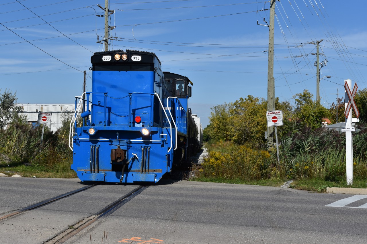 GMTX 333 leads half a dozen freight cars southbound through downtown Brampton on its way to Streetsville to interchange with CP. They are crossing over Railroad st and the Halton in this scene and this way the odd morning when the train came at a good time where they would not get stuck behind one of the half-hourly scheduled GO Trains on the Halton. 
Time: 11:12